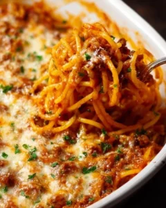 A plate of Million Dollar Spaghetti garnished with herbs and cheese