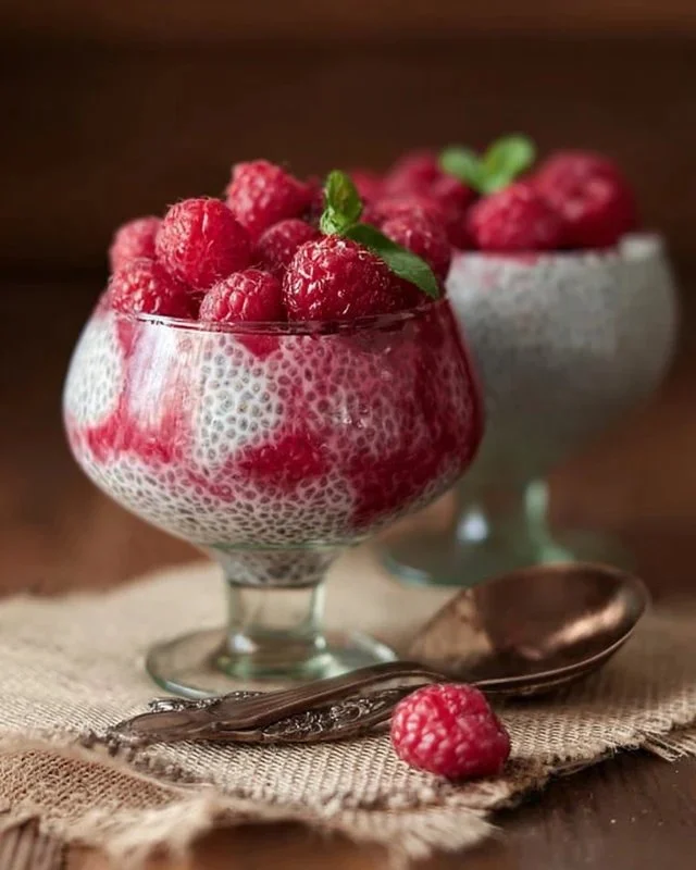 Vanilla Raspberry Chia Pudding in a glass cup with fresh raspberries